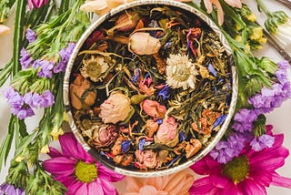A container with herbs, flowers, plants and roots with various colors.