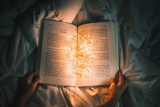 An open book with fairy lights coming out signifying imagination.