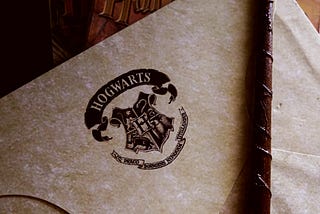 A letter from Hogwarts with a wand on top of it