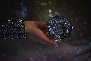 A hand holding a shiny diamond-studded ball, showing how you were meant to shine.