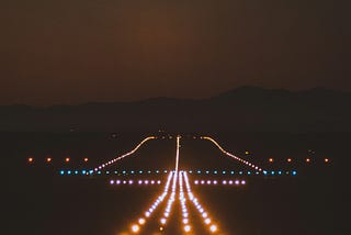 Photo of a plane landing runway lit up
