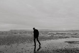 A man walks solo on the beach