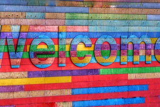 A sign reading welcome made of multi-coloured wood planks