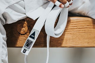 Holding a white belt.