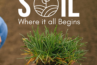 A clump of grass and dirt being held within a woman’s hands. Text reads “Soil. Where it all Begins.”