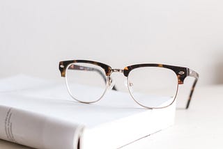 A pair of glasses on a book — or how I switch from reading to writing
