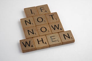 Several scrabble letters arranged to read: “if not now, when”.