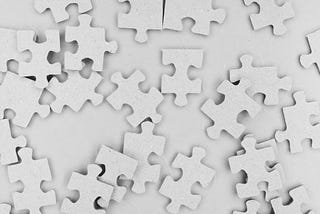 White puzzle pieces scattered on white background