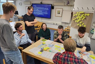 Teachers and game designers working on a paper prototype of Industrial Re:evolution.