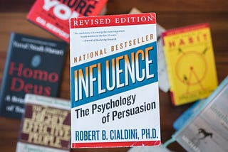 Small pile of self-growth books. Focused emphasis on Influence, The Psychology of Persuasion.