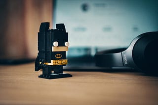 Figurine and headphones on a desk