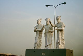Statue of three wise men in Lagos, Nigeria. Each statue is of a white cap chief with slightly different hand gestures