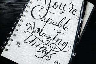 “You’re capable of amazing things” written in bold cursive on a notebook page