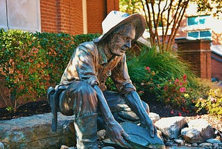 a statue of a miner panning for gold