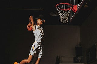 A basketballer throwing ball into a hoop