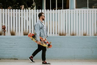 a man carrying a colorful skateboard
