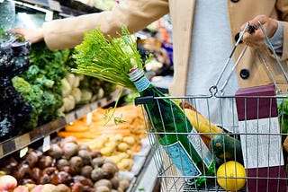 A woman shopping at the supermakret, she’s choosing the type of veggie she wants to bring at the table