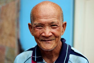 A smiling old man looking at you