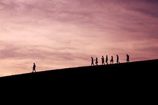 People walking with one person leading the way.