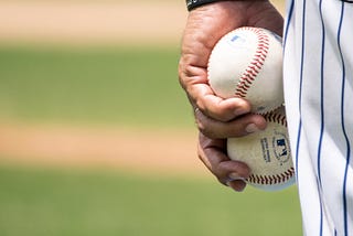 Baseball player holding two baseballs