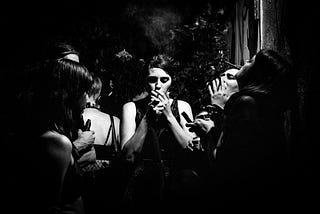 People smoking and drinking at a club.