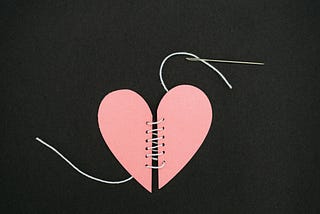Illustration of a stitched and sewn-up heart symbolizing emotional healing after heartbreak
