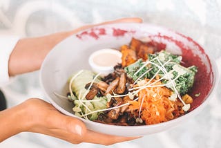 A person holding a plate of food.