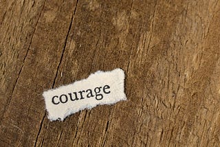 Piece of paper with “courage” written on it on the ground