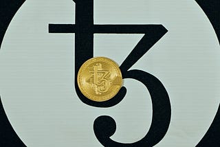 A gold Tezos coin placed on Tezos background 