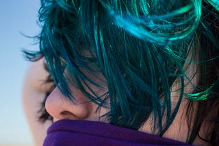 Side profile of person with blue highlights in dark hair. Inspiration for pride poem