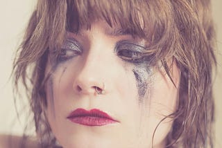 Woman with smudged make-up, implying she’s been crying