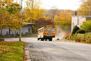A school bus drives down a street.