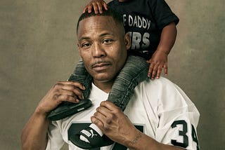 (Pictured: Dion Coleman and his son — Photo Credit: Aaron Jay Young)