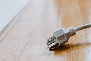 a white plug on a wooden floor