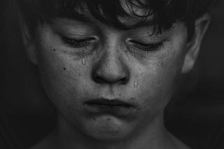 Black and white photo of boy crying. Death. Nobles.