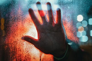 A blurred hand on a washed background signifying the obstruction of present life