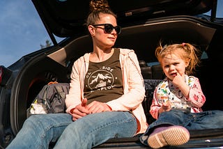 mother and daughter talking in the back of the car