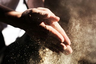 Hands clapping together with particle dust flying around