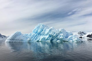 A melting glacier falling into water.