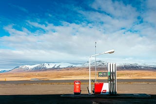 a photo of a gas pump with mountains behind it