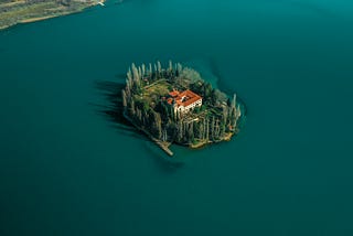 Aerial view of a beautiful private island with a red-roofed estate surrounded by deep blue water, symbolizing isolation, success, and the emotional tension of outgrowing what once felt ideal.