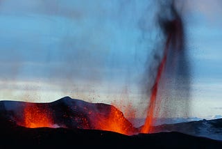 A picture of an active volcano, with red hot flames and spewing ash