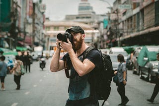 Man taking a picture with a DSLR in the city