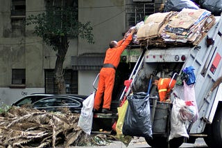 A man on a garbage truck
