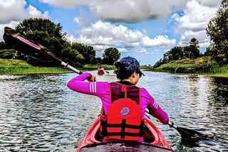 A girl is paddling in a kayak