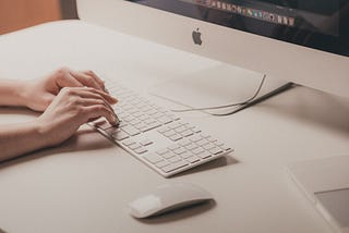 Minimal tech beige-gray aesthetic image of someone typing on a keyboard.