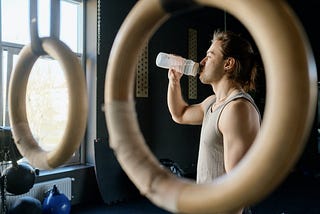 Man Drinking from Water Bottle at the gym