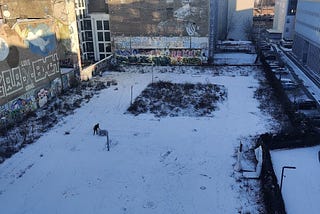 The view from my balcony on the morning of 21st January 2022, after a night of heavy snowfall in Berlin. The basketball court and the road leading up to the river Spree covered in snow.