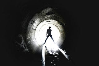 A man standing in an ambiguis and unclear tunnel that sparks creativity