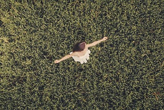top-down view of girl twirling on grass